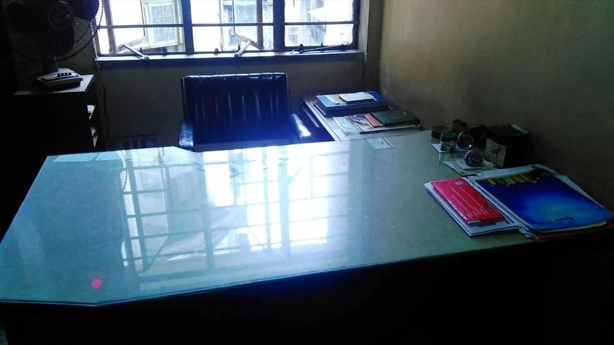 Bright workspace featuring a large glass-topped desk near a window.