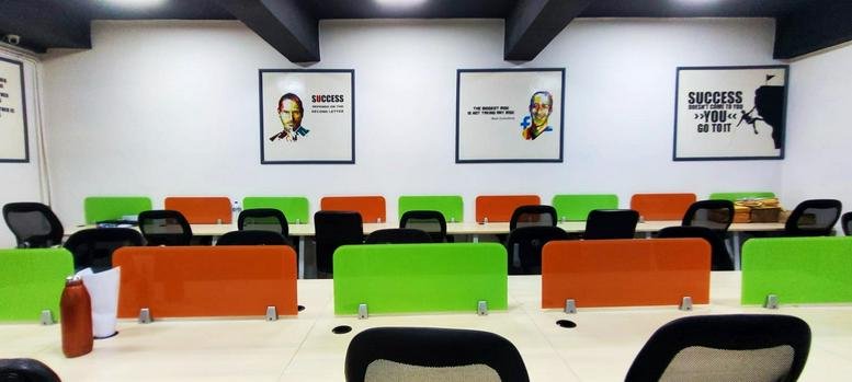 Spacious coworking area at Workobar Coworking Space in ACE CHAMBER Tilak Nagar with green and orange dividers.
