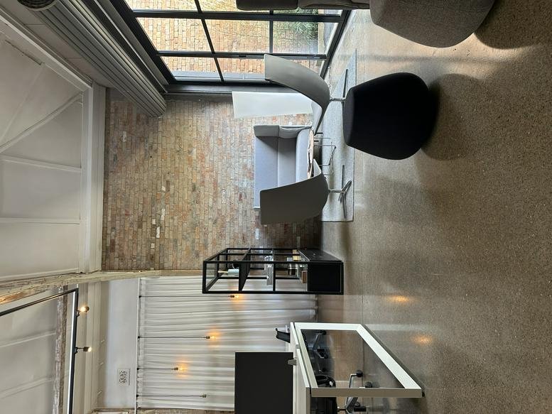 Spacious communal lounge at 317-319 High Street, Maitland featuring exposed brick and modern seating.