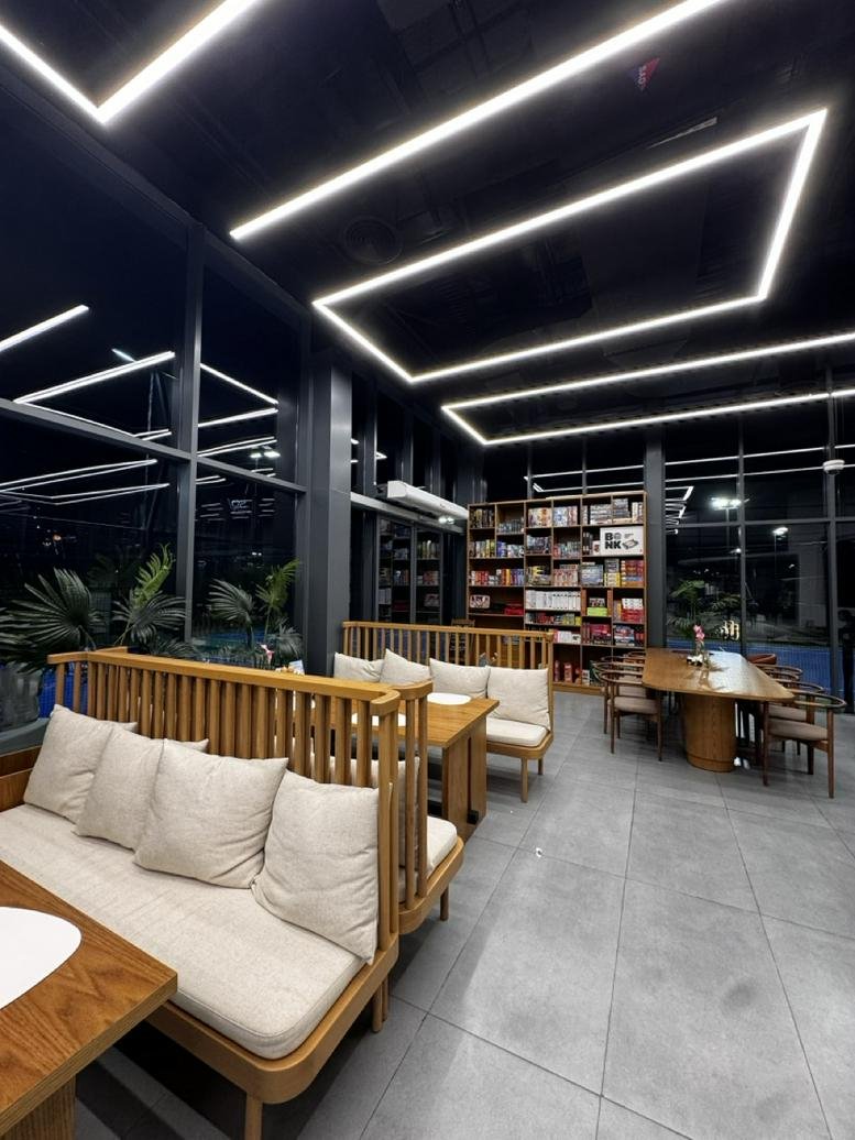 Spacious communal lounge at 347R+6J, Al Thanyah Fifth with wooden booths and modern strip lighting.