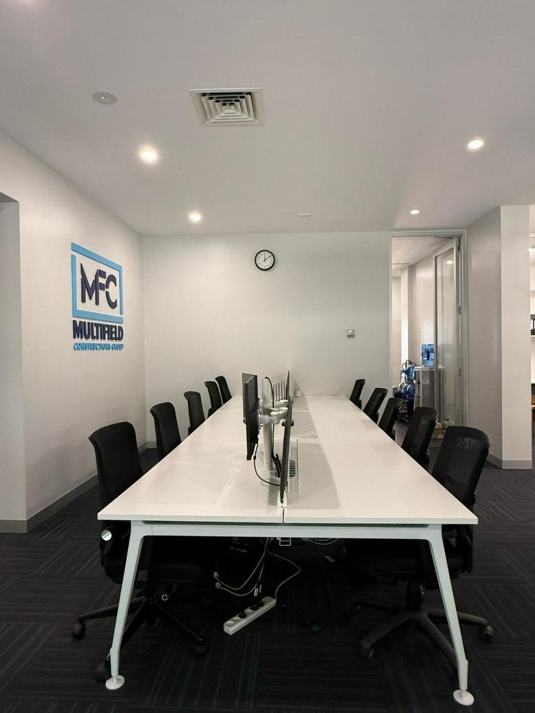 Spacious open-plan office with a long white communal desk and branded wall at 366-370, Spencer Street, Melbourne.