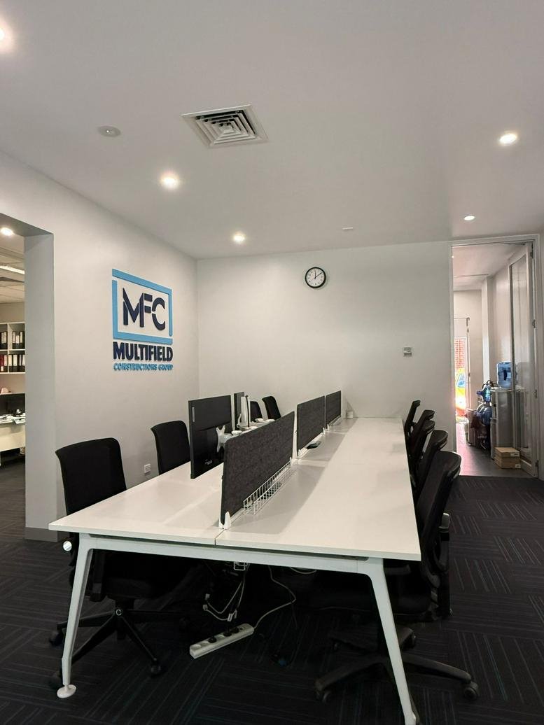 Open-plan office space at 366-370 Spencer Street featuring rows of workstations and white walls.