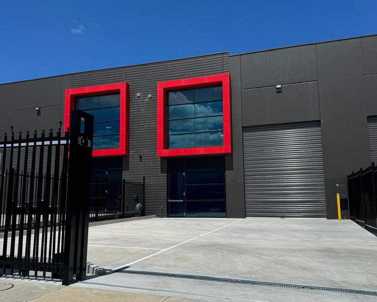 Modern charcoal-grey exterior of 41 Gawan Loop with distinctive red-framed windows and high roller door.