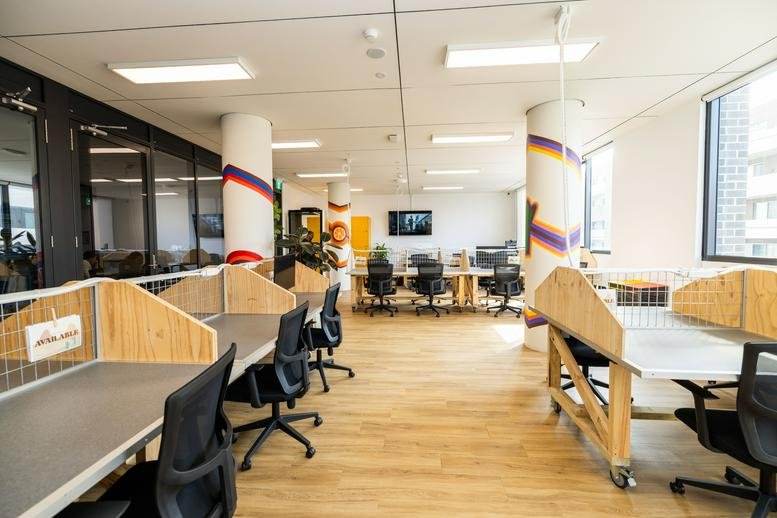 Spacious open-plan workspace at 5 Blake Street, Kogarah, Sydney with colorful pillars and wood-look flooring.