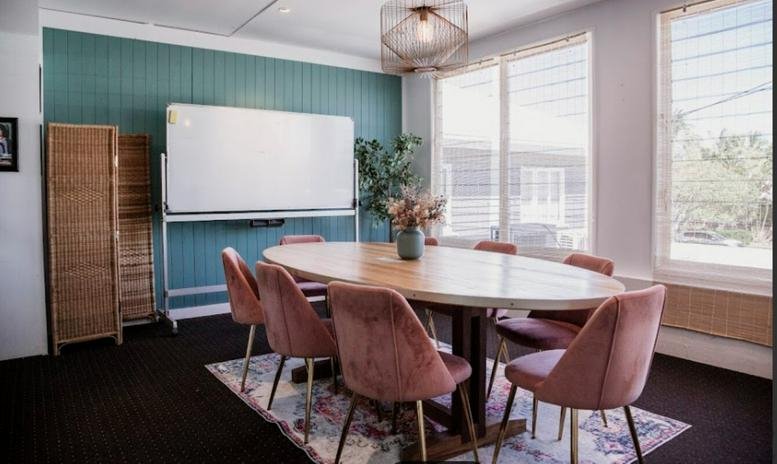Meeting room at 7/10 Thomas Street, Noosaville, Queensland with pink velvet chairs and a large whiteboard.