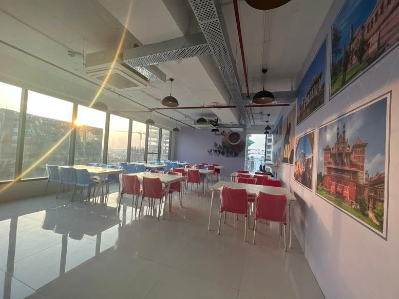 Sunny dining area at 73 East Avenue with colorful red chairs and large windows.