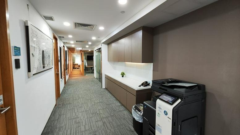 Long hallway at 8/F, Rykadan Capital Tower featuring a copy machine and built-in wooden cabinetry.