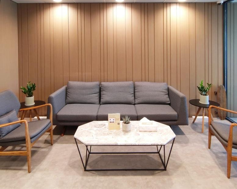 Spacious reception lounge at 88 Hing Fat Street with grey sofas and marble coffee table.