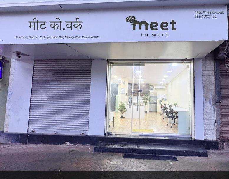 Exterior view of the entrance to Arunodaya Building Office no 1 and 2 with glass doors and signage.