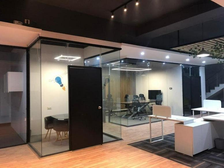 Modern reception area at B-38, Old DLF, Stand Alone Building, Gurugram with glass partitions and wooden floors.