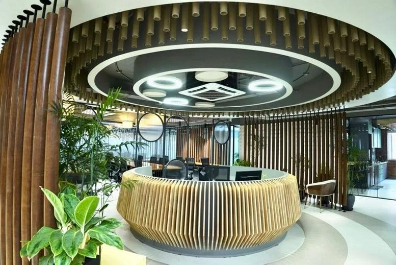 Modern circular reception desk with slatted wood details and a unique designer ceiling.