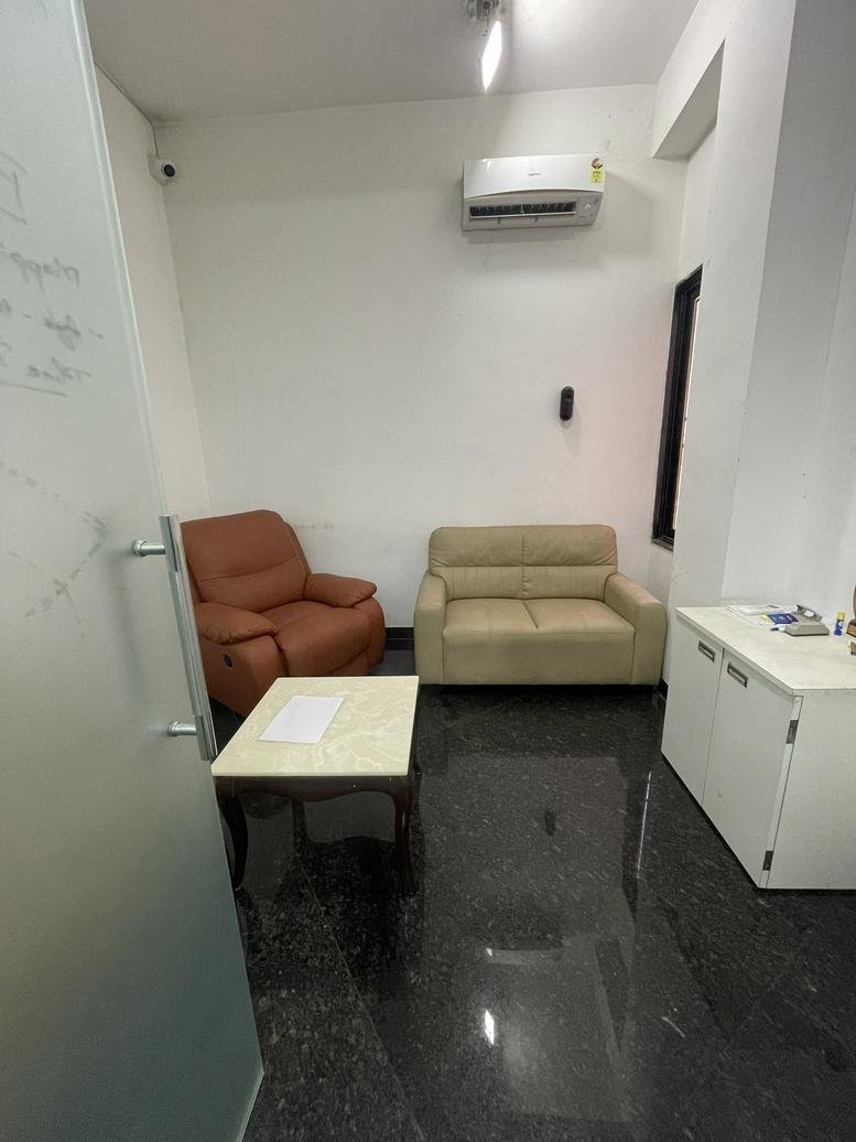 Waiting area at C-240/6, Vallabh Nagar, featuring a brown recliner and beige sofa with a marble coffee table.