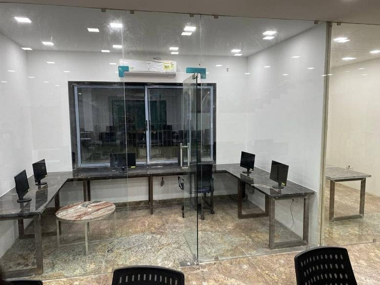 Spacious open-plan workspace at C245, 246/6, Vallabh Nagar with glass partitions and multiple workstations.