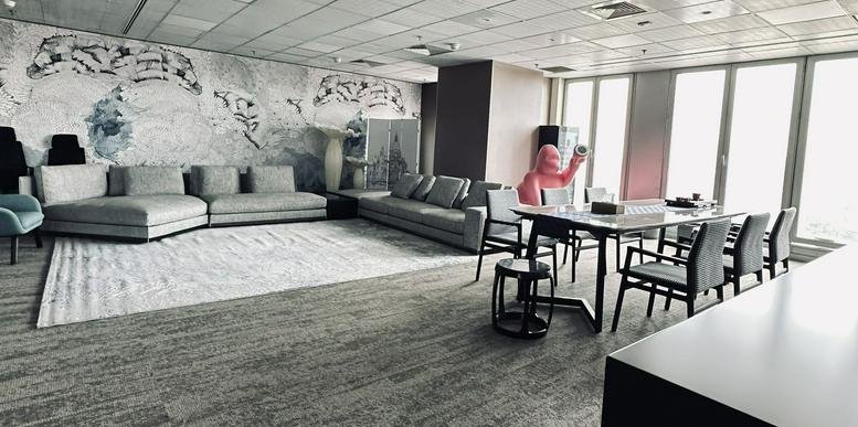Spacious communal lounge featuring a large sectional sofa and a mountain mural.