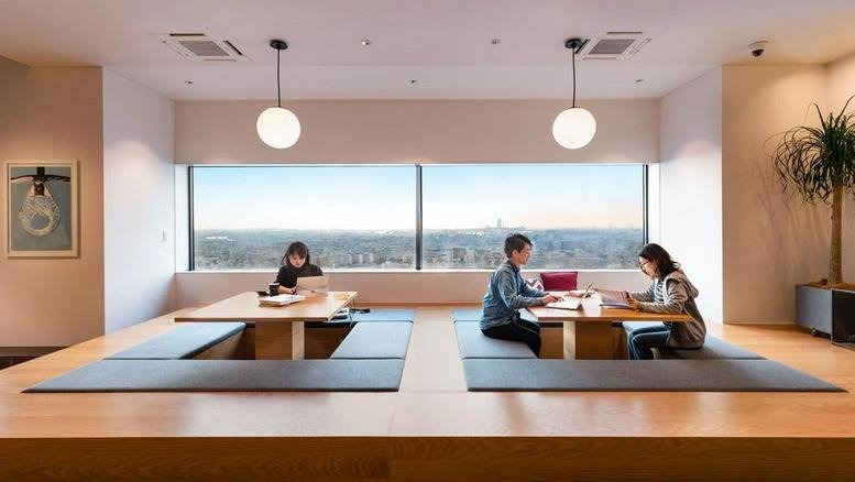 Sunken seating area with two tables and window views.