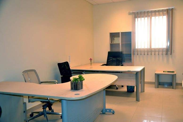 Spacious private office at Building No. 6143 with curved white desks and natural light.