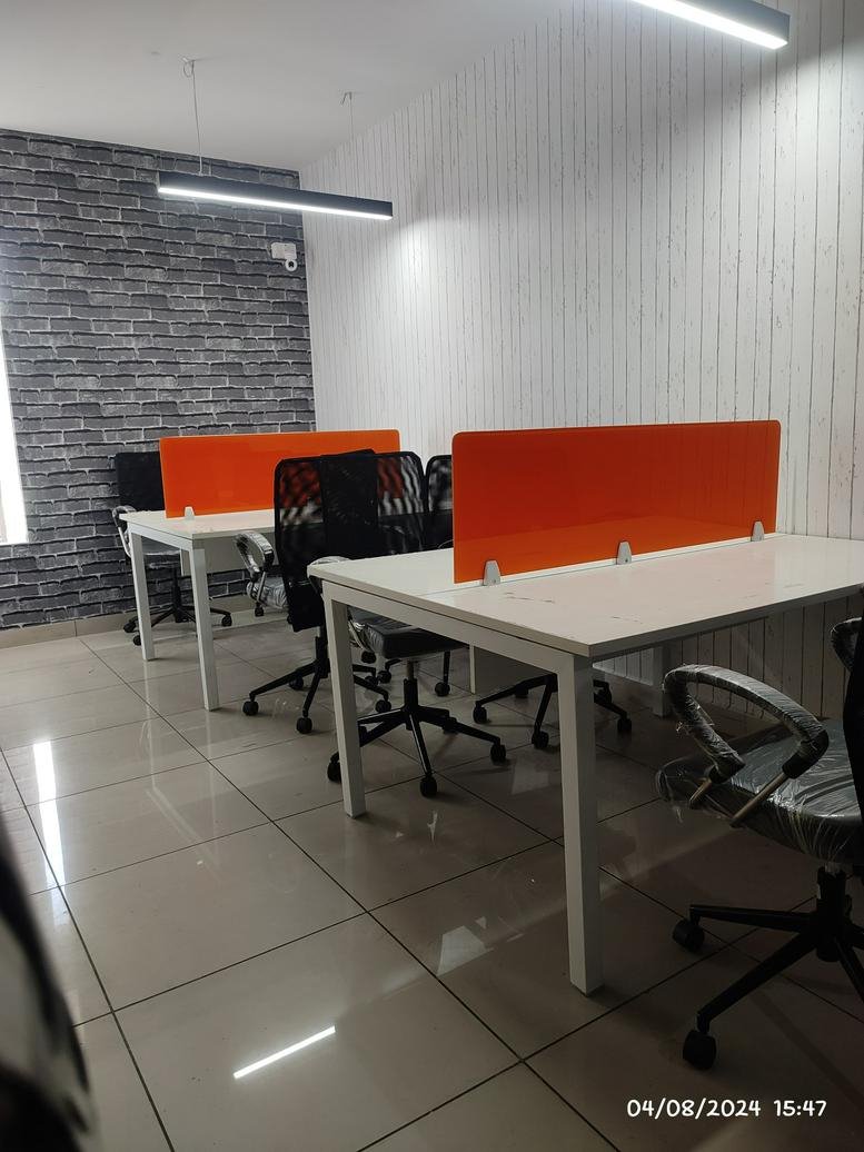 Spacious open-plan coworking area at No. 402, HBCS Layout with white desks and orange privacy screens.
