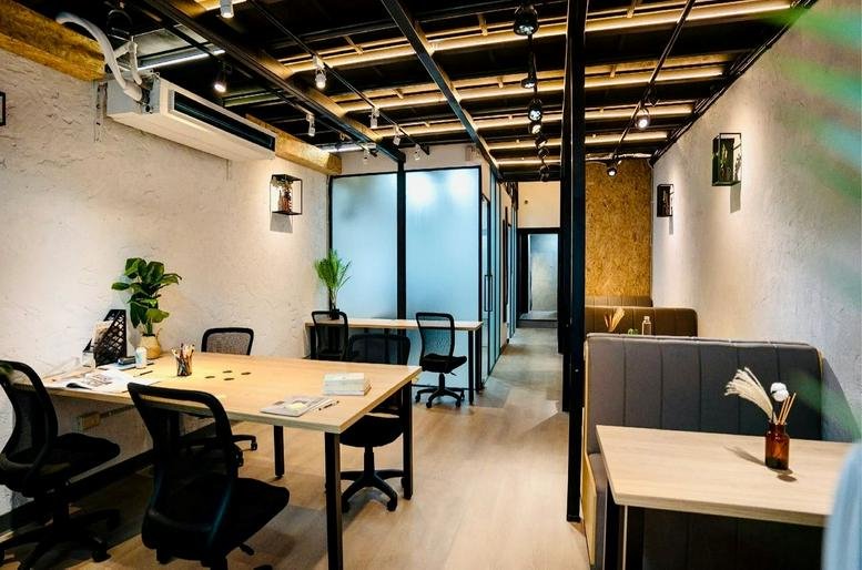Spacious open-plan workspace at No. 24 Nanyang Street, 2F with wooden desks, ergonomic chairs, and industrial ceiling.
