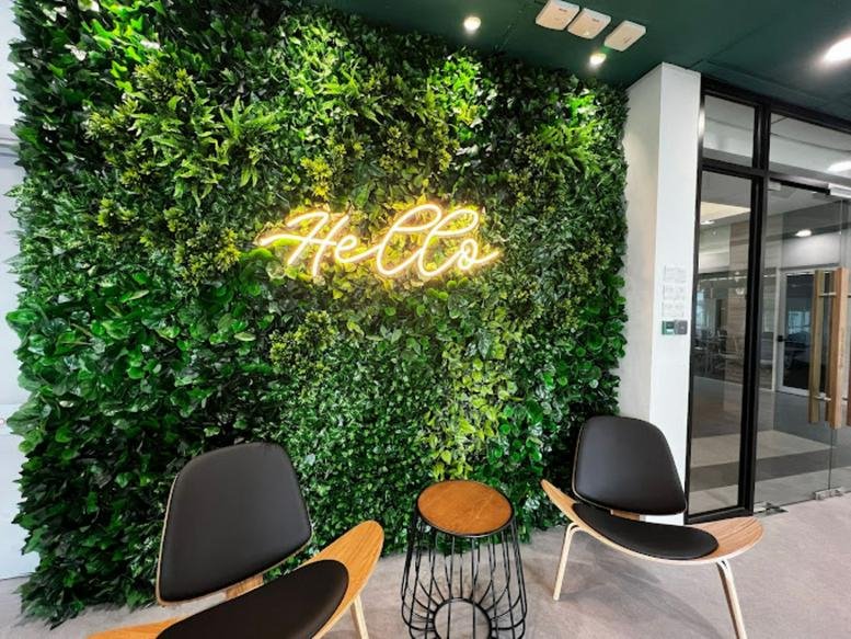 Reception area with green wall and neon 'Hello' sign
