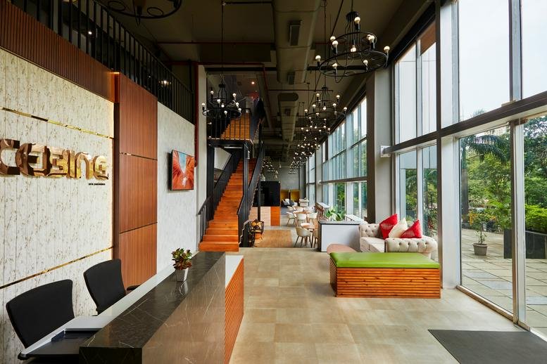 Bright lobby at Park Site Road, HMPL Surya Nagar, Mumbai with wood reception desk and floor-to-ceiling windows.