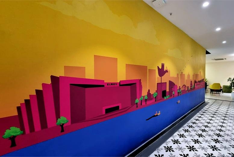 A vibrant hallway at Plot No. 213, Industrial Area Phase 1 featuring a colorful city mural and patterned floor.