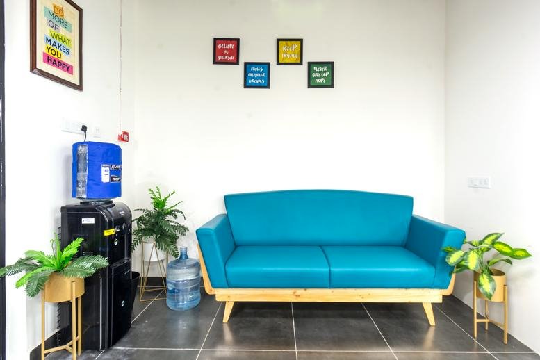 Bright reception lounge at Plot No. 4/1, Survey No. 64, Huda Techno Enclave with a teal sofa.