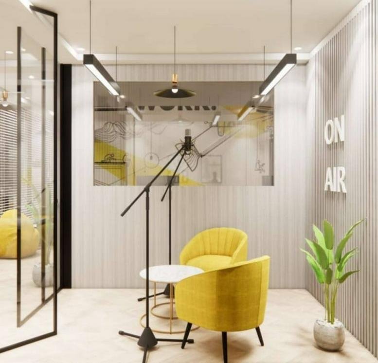 Meeting area at Plot No. D-C2, Lal Kothi Scheme featuring yellow armchairs and a recording microphone setup.