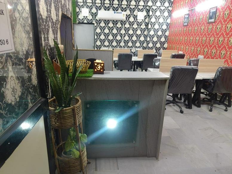 Reception area at SCO 32, Adjacent HDFC Bank, Sector 56, Phase 6, Mohali with a grey desk and patterned wallpaper.