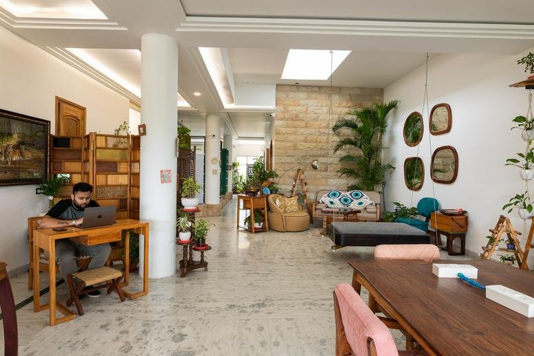Spacious open-plan coworking area with white pillars and diverse seating options.