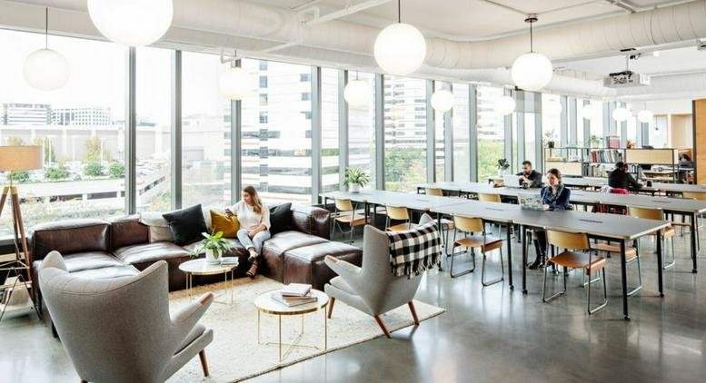 Spacious communal lounge at 101 Chao Yang Bei Lu with a large leather sofa and long communal work tables.