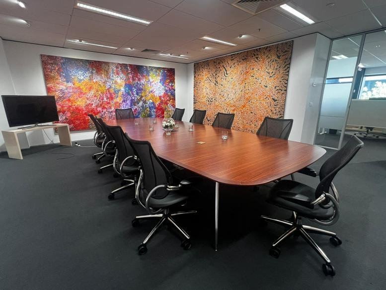 Professional meeting room with a dark carpet and colorful wall-to-wall art.