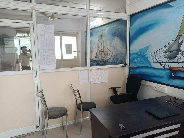 Private office room with metal chairs, a desk, and a bright blue maritime wall mural.