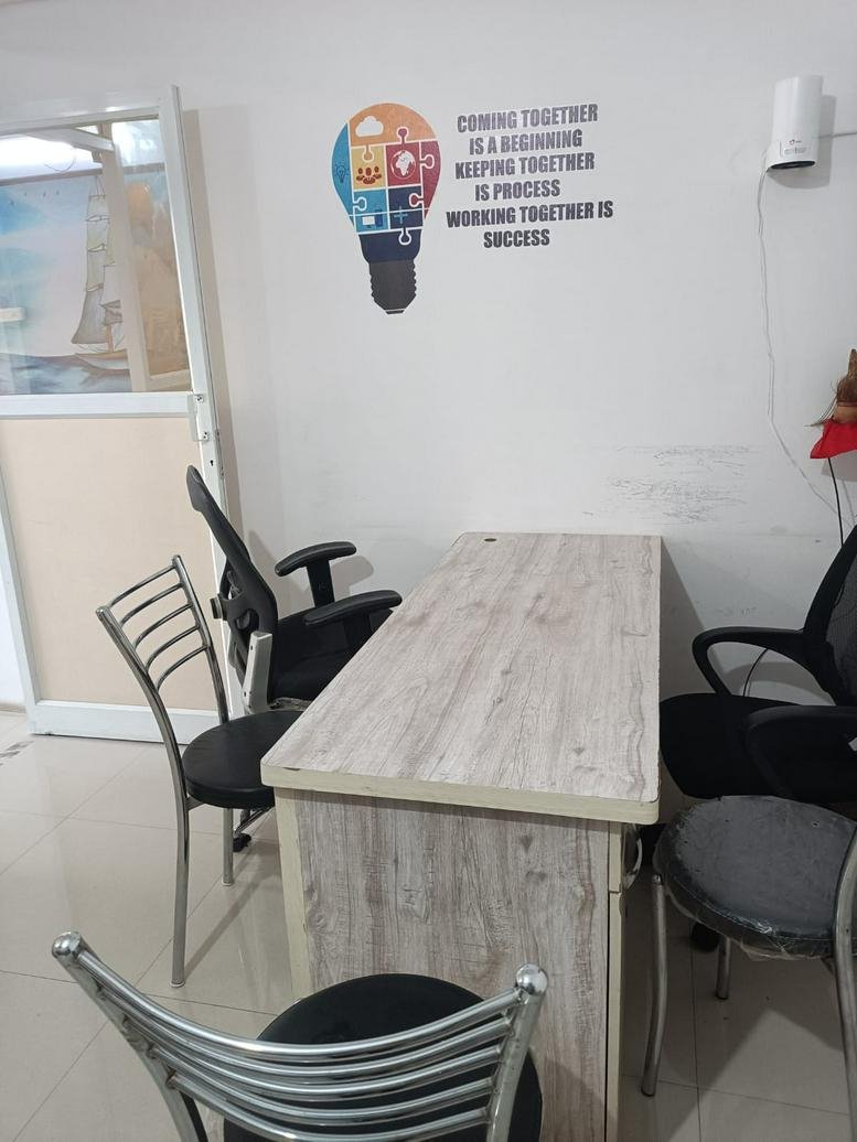 Light wood desk at 257 Mankar Chowk Road with motivational wall graphics and task chairs.