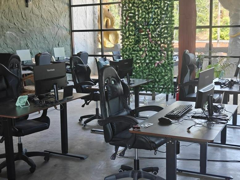 Wide-angle view of the bright coworking space at 2F 641, Koh Lanta, Thailand with gaming chairs.