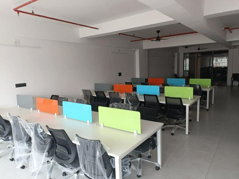 Spacious open-plan workspace at Golden Plaza, 523, S. P Ring Road featuring colorful desk dividers.