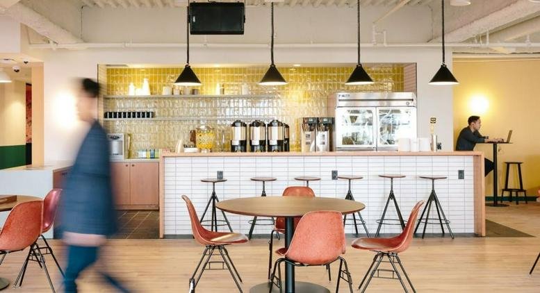 Cafe area with a white tile bar, red chairs, and hanging pendant lights at 6 Jiuxianqiao Lu, Chaoyang District, Beijing.