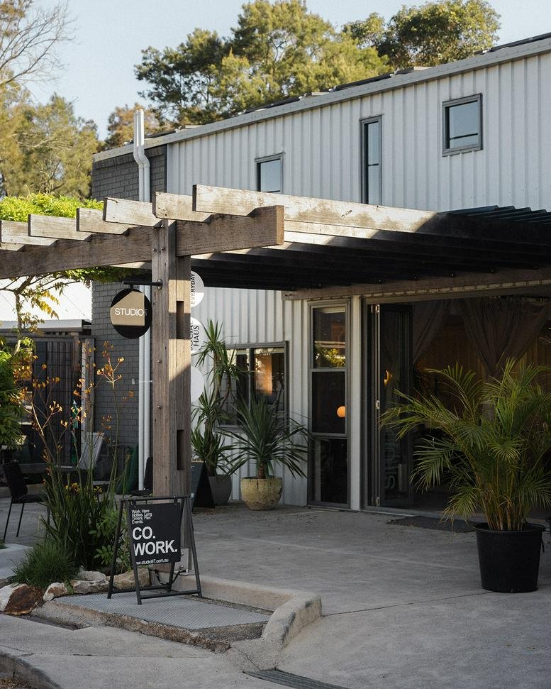 Exterior view of the corrugated metal facade and timber pergola at Studio97.