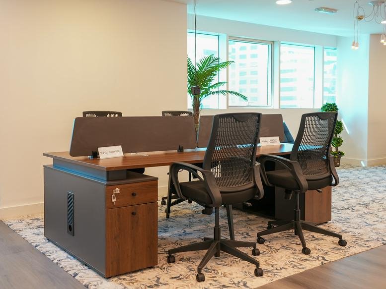 Modern open-plan workstations with ergonomic chairs and wooden filing cabinets.