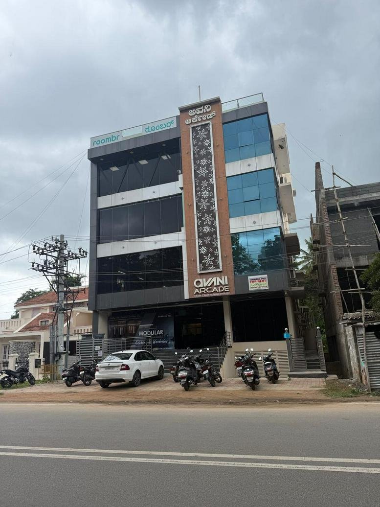 Exterior view of the multi-story Avani Arcade with a glass facade and central decorative panel.
