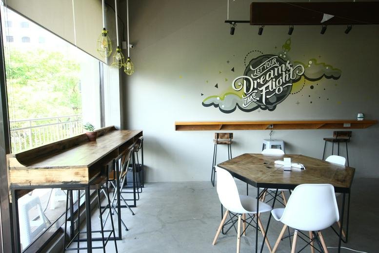 Bright communal break area at Commercenter Alabang with a geometric table and wall mural.