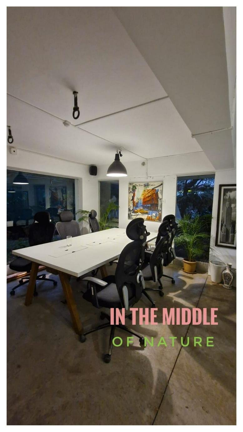 Meeting room at Gulawani Maharaj Road, Nal Stop Metro, Pune, India featuring a large white table and black mesh chairs.