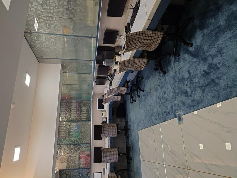 Spacious open-plan office at Mahaveer, 99 Lajpatrai Road with modern workstations and blue carpeting.