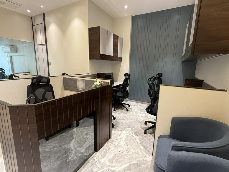 Reception area at Mahinder Chambers with dark wood paneling and blue armchairs.