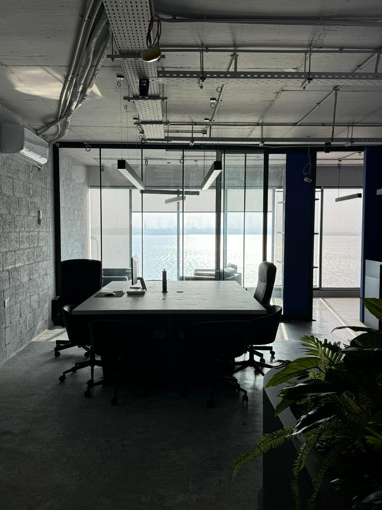 Modern meeting room with glass walls and waterfront view.