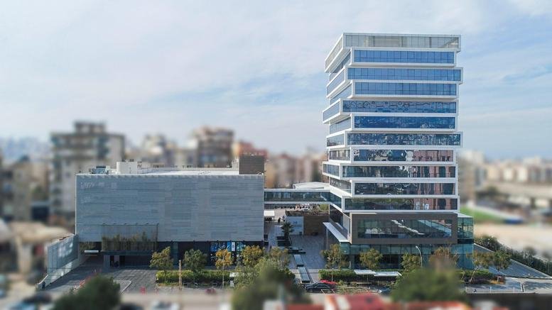 Daytime exterior wide shot of The Bridge Center showing its unique stacked glass architecture and bridge.