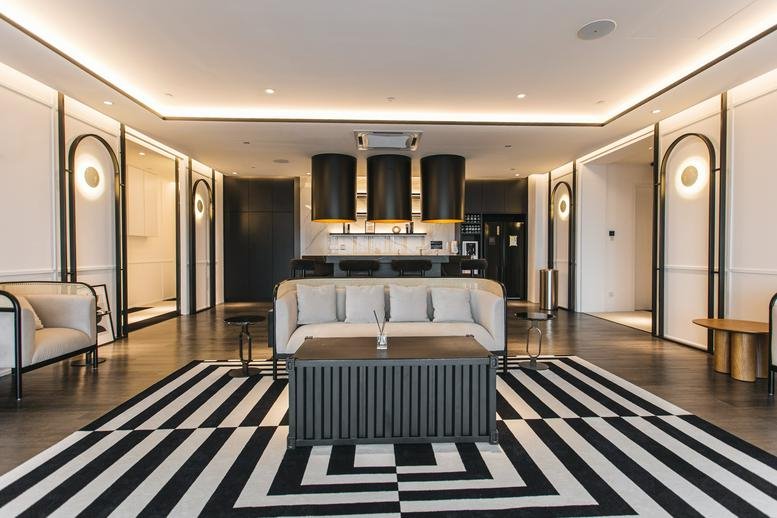 Spacious designer lounge at The MET Corporate Towers with bold striped rug and modern furniture.