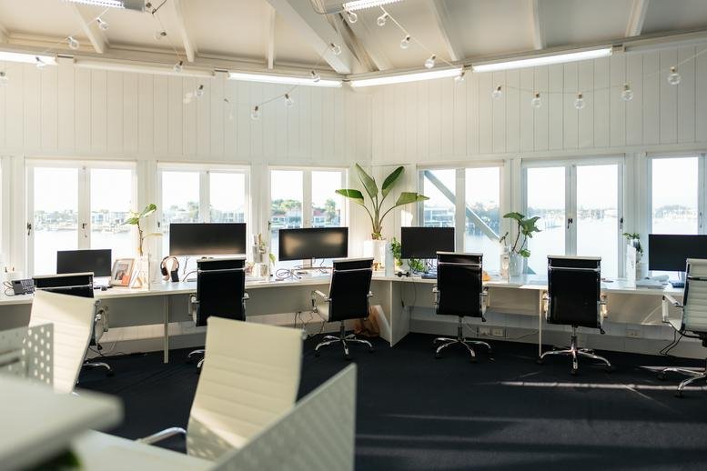 Spacious open-plan workspace at The Wharf Mooloolaba with numerous desks and waterfront views.
