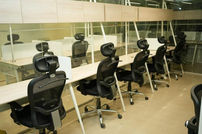 Spacious open-plan coworking area at Hamid Building with ergonomic chairs and glass partitions.