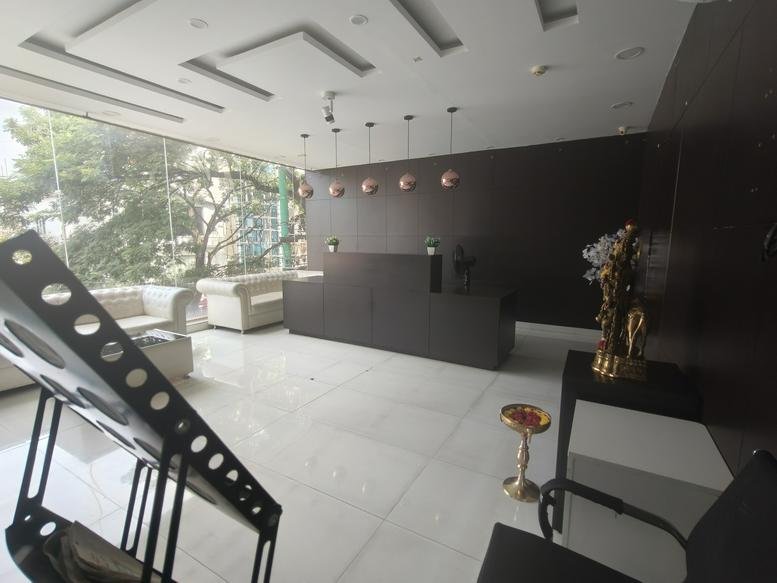 Spacious reception area of cubiqo featuring a dark wood desk and designer pendant lighting.