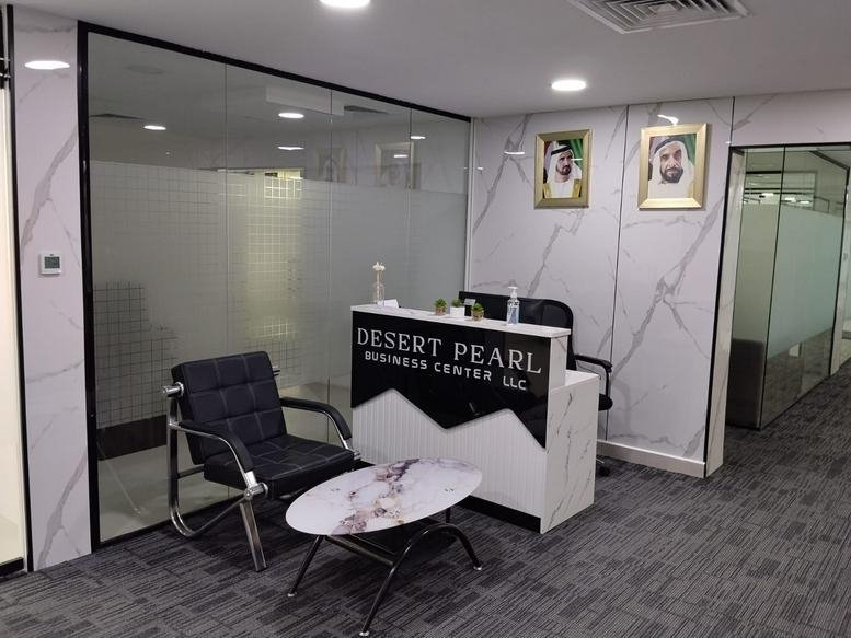 Reception area at Desert Pearl with a branded front desk and marble-patterned walls.